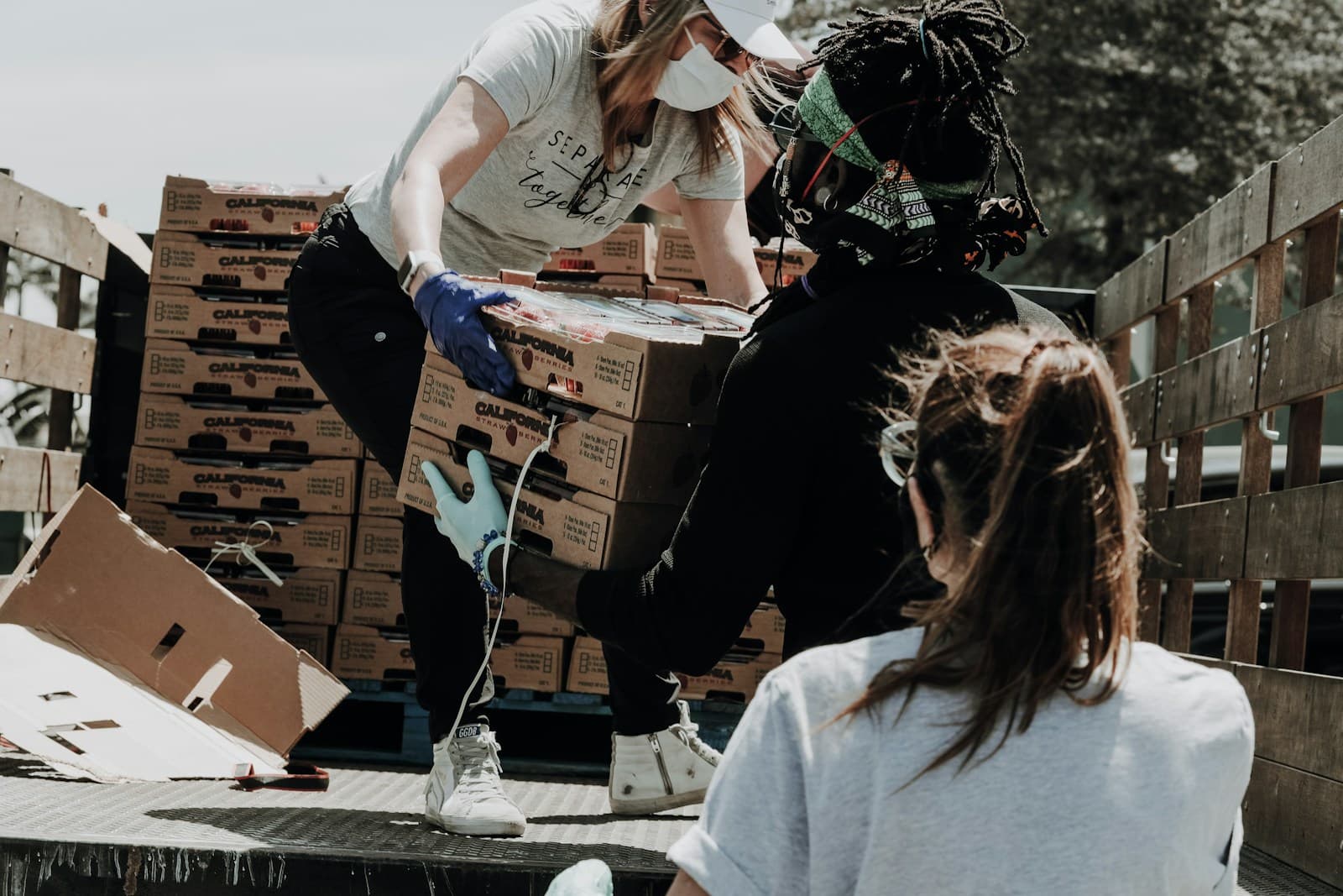 Volunteers sorting donated food and supplies at a busy community distribution table.
